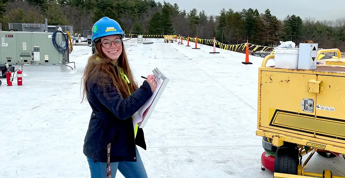 female commercial roofing specialist with a clipboard