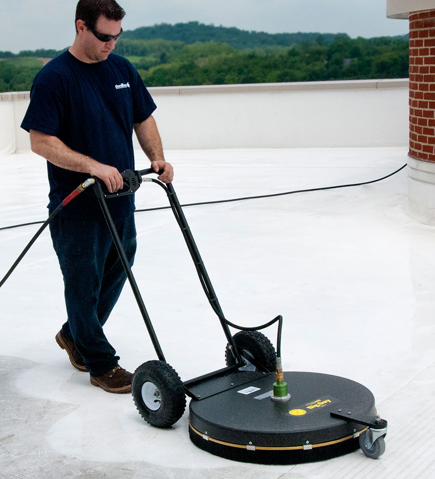 roofer pressure washing a flat roof
