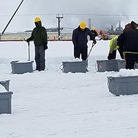 roofers removing snow and ice from commercial roof