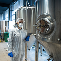 a brewery worker by the tank