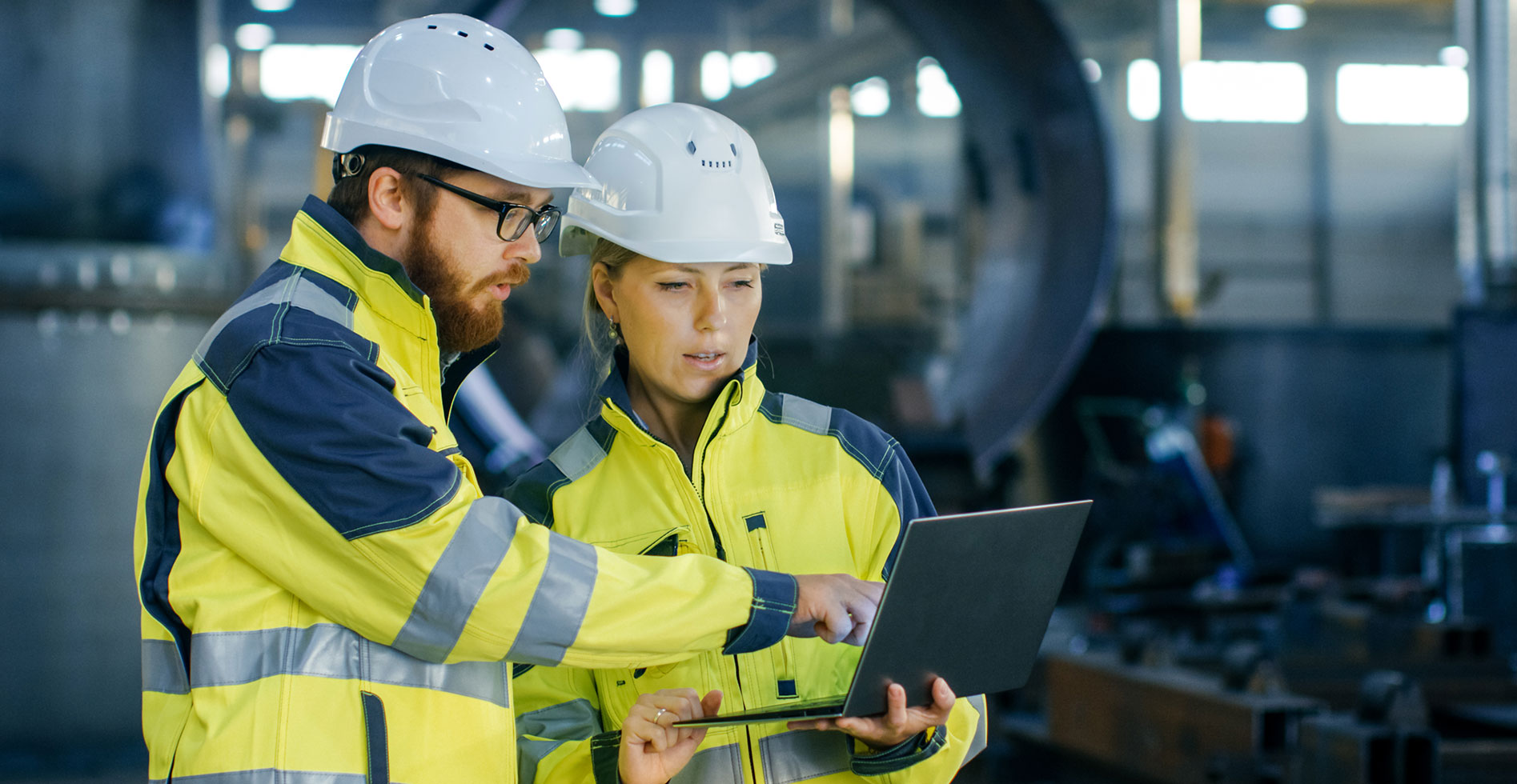 two engineers are discussion something on a laptop